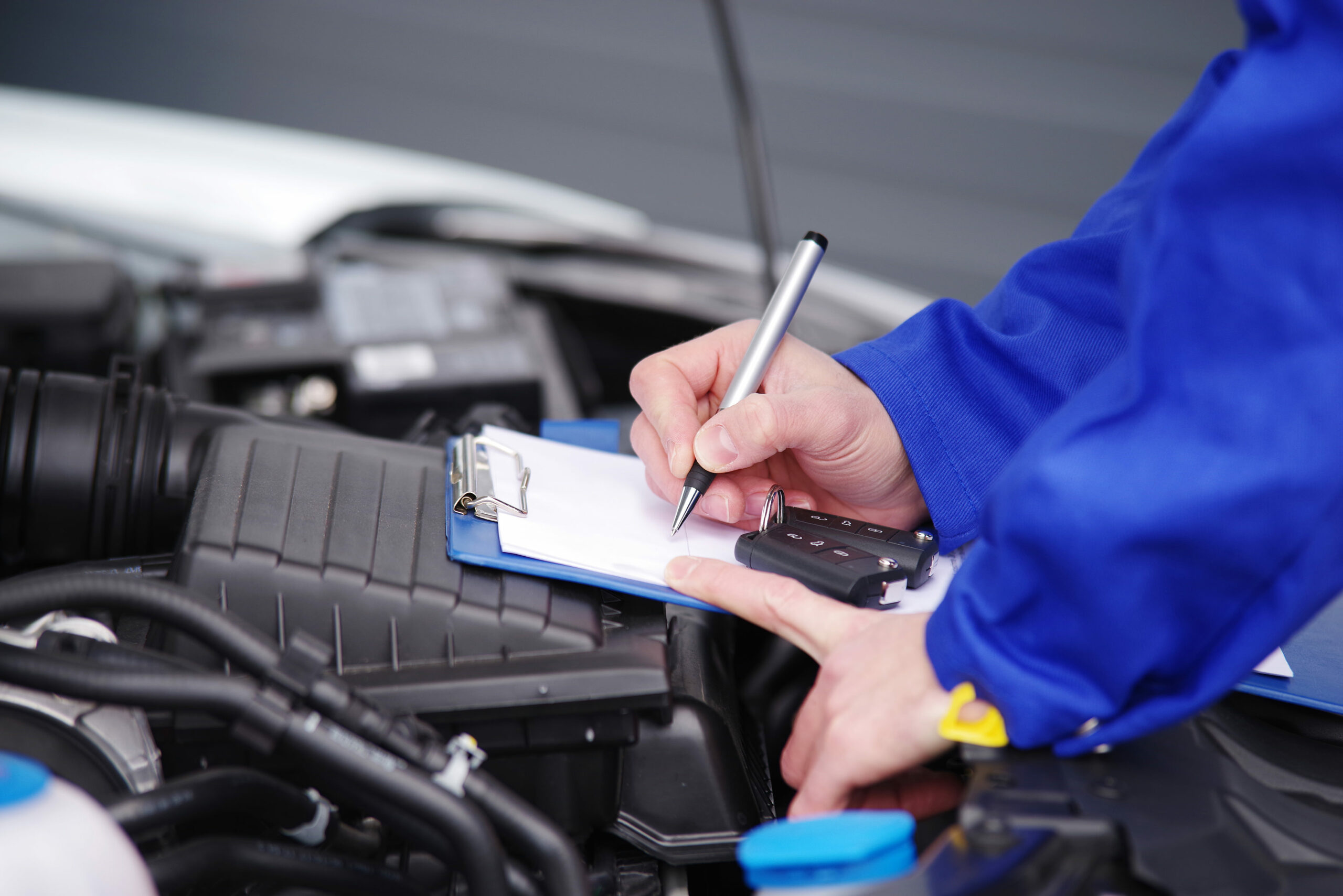 Mechaniker bei der Durchsicht eines Autos, TÜV-Untersuchung